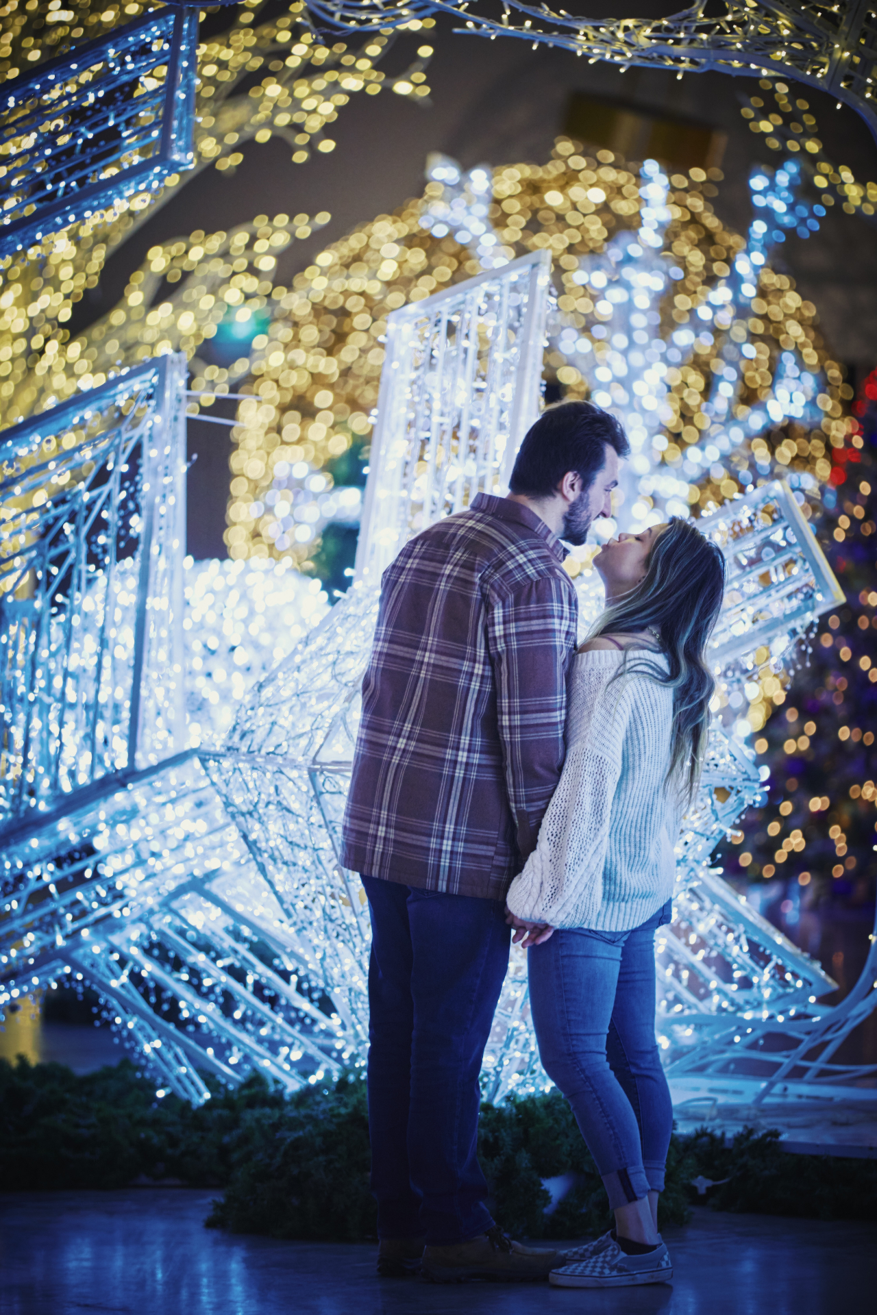 Couple sharing a moment beneath glowing star light installations at Holiday Wonder